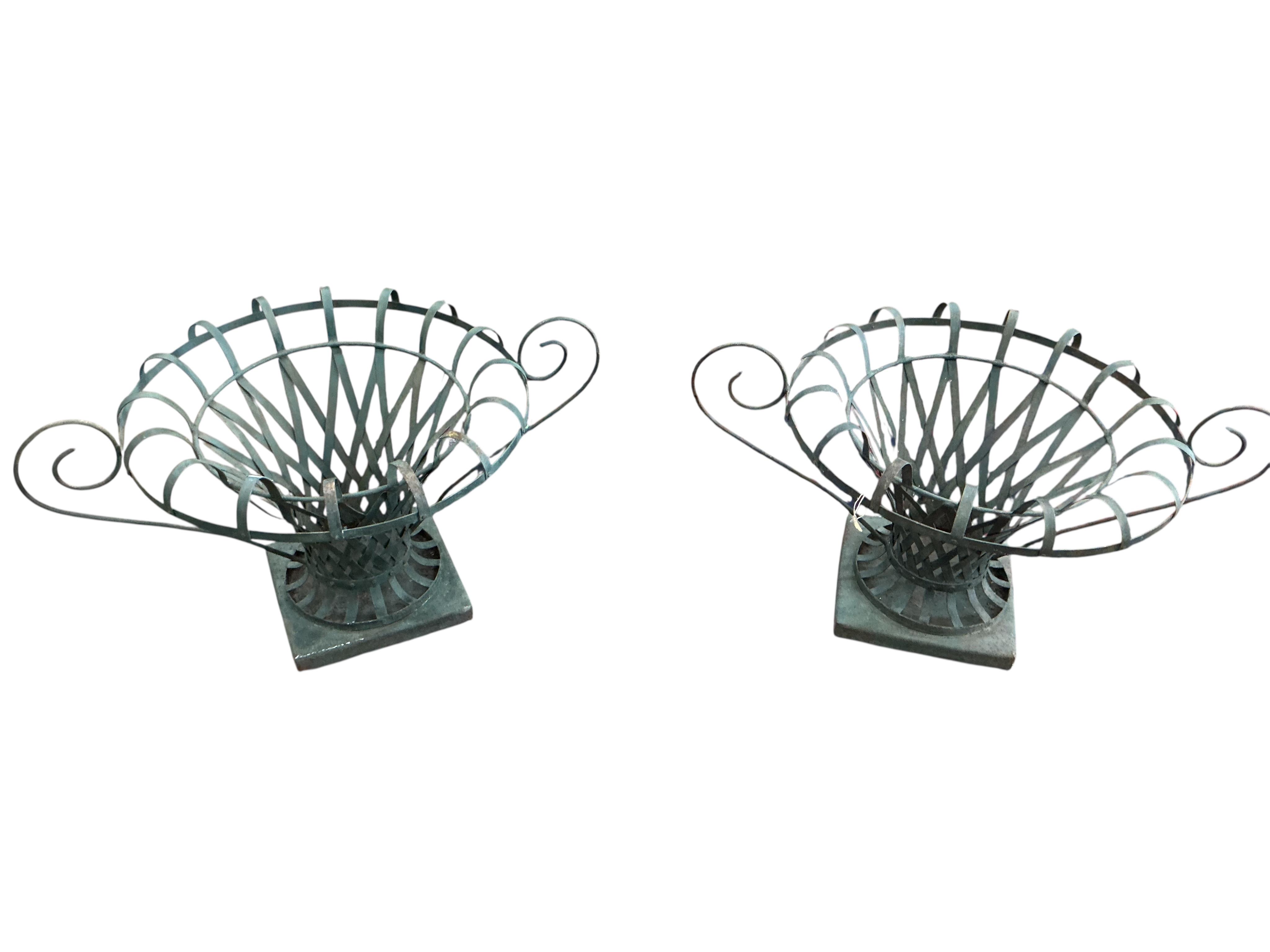 A pair of large painted wrought iron strapwork flower urns, diameter 90cm, height 44cm